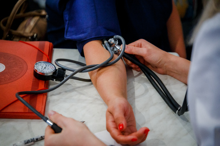 Close up view of female medicine doctor measuring blood pressure to her patient. Hands close up. Healthcare, healthy lifestyle and medical service conceptの写真素材