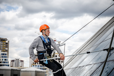 MINSK, BELARUS - 02 JUNE. 2018: group of workers cleaning windows service on high rise building....