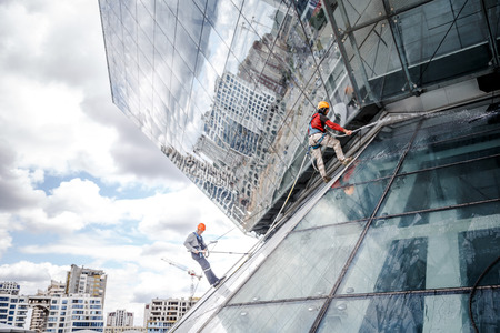 MINSK, BELARUS - 02 JUNE. 2018: group of workers cleaning windows service on high rise building. work on the heights , industrial mountaineeringのeditorial素材