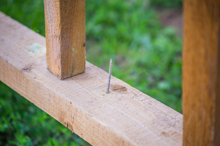 a nail sticks out of a broken board