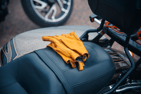 leather motorcycle gloves is lying on a bikeの写真素材