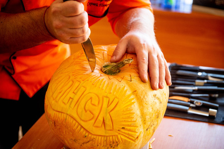 man carving on a pumpkinの写真素材