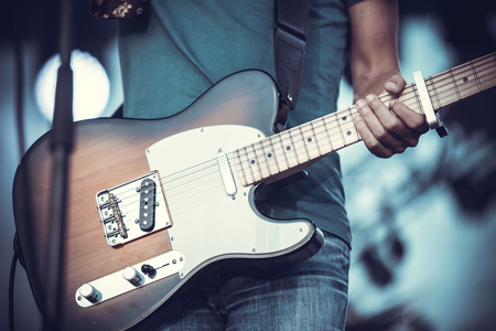 rock musician holding a guitar and playing itの写真素材