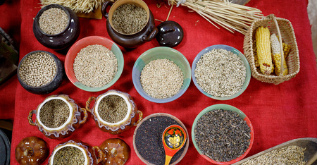 uncooked grains of rye wheat oats rice in old Russian pots and bowlsの写真素材