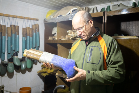MINSK, BELARUS - 25 DECEMBER, 2018: the man is making felt boots in his workshopのeditorial素材
