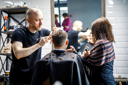 MINSK, BELARUS - 1 APRIL, 2019: a guy with down syndrome get a haircut in barbershopのeditorial素材