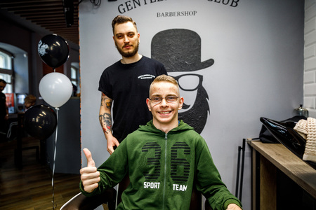 MINSK, BELARUS - 1 APRIL, 2019: a guy with down syndrome get a haircut in barbershopのeditorial素材