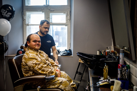 MINSK, BELARUS - 1 APRIL, 2019: a guy with down syndrome get a haircut in barbershopのeditorial素材
