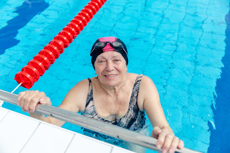 MINSK, BELARUS - 1 JUNE, 2019: Happy senior woman relaxing in swimming poolのeditorial素材