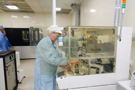 MINSK, BELARUS - February 25, 2020: Electronics Factory Worker a Printed Circuit Board Through a Digital Microscope High Tech Factory Facilityのeditorial素材
