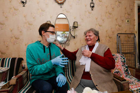 MINSK, BELARUS - February 25, 2020:  social worker volunteer helps old woman coronavirusのeditorial素材