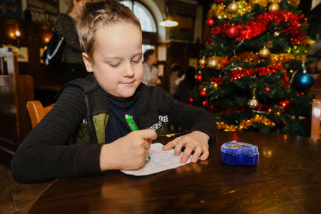 MINSK, BELARUS - February 25, 2020: boy writes a letter to santa clausのeditorial素材