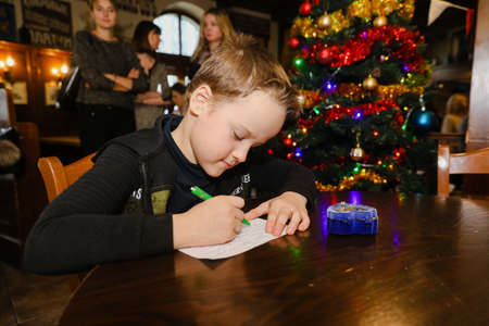 MINSK, BELARUS - February 25, 2020: boy writes a letter to santa clausのeditorial素材
