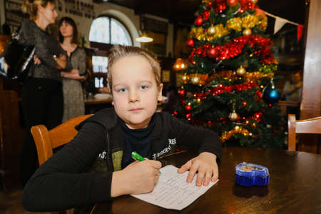MINSK, BELARUS - February 25, 2020: boy writes a letter to santa clausのeditorial素材