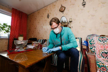 MINSK, BELARUS - February 25, 2020:  social worker volunteer helps old woman coronavirusのeditorial素材