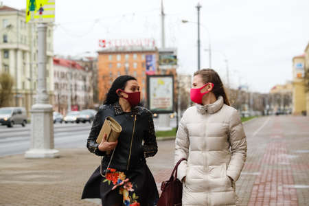 MINSK, BELARUS - 1 MARCH, 2020: two womans in protective masks from coronavirus walk along the city streetのeditorial素材