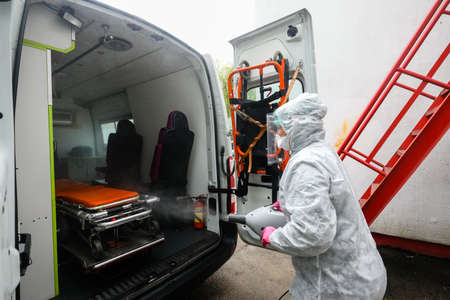 MINSK, BELARUS - 1 MARCH, 2020: woman disinfects ambulance from coronavirusのeditorial素材