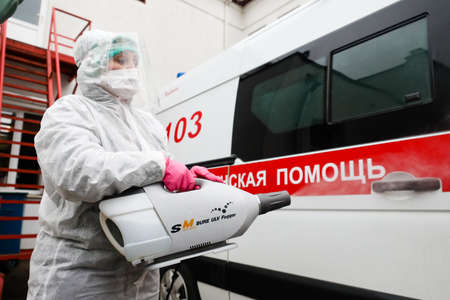 MINSK, BELARUS - 1 MARCH, 2020: woman disinfects ambulance from coronavirusのeditorial素材