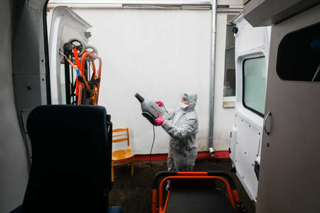 MINSK, BELARUS - 1 MARCH, 2020: woman disinfects ambulance from coronavirusのeditorial素材