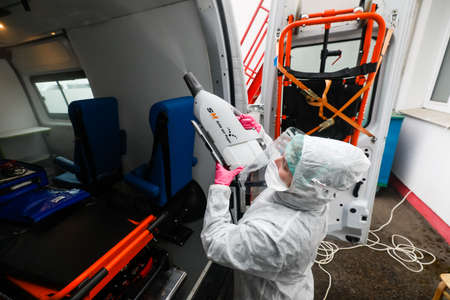 MINSK, BELARUS - 1 MARCH, 2020: woman disinfects ambulance from coronavirusのeditorial素材