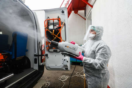MINSK, BELARUS - 1 MARCH, 2020: woman disinfects ambulance from coronavirusのeditorial素材