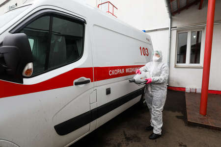 MINSK, BELARUS - 1 MARCH, 2020: woman disinfects ambulance from coronavirusのeditorial素材