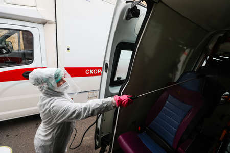 MINSK, BELARUS - 1 MARCH, 2020: woman disinfects ambulance from coronavirusのeditorial素材