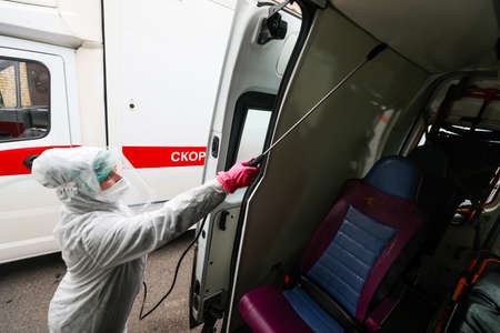MINSK, BELARUS - 1 MARCH, 2020: woman disinfects ambulance from coronavirusのeditorial素材