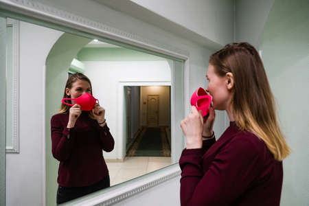 MINSK, BELARUS - 1 MARCH, 2020: young girl puts on a protective mask against coronavirusのeditorial素材