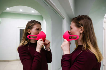 MINSK, BELARUS - 1 MARCH, 2020: young girl puts on a protective mask against coronavirusのeditorial素材