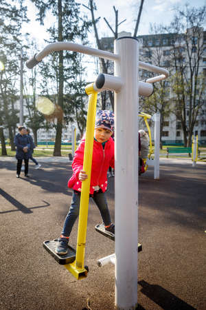 MINSK, BELARUS - 1 MAY, 2019: children, adults and old people exercise on outdoor exercise machinesのeditorial素材