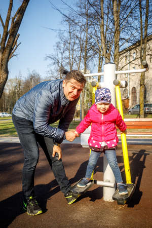 MINSK, BELARUS - 1 MAY, 2019: children, adults and old people exercise on outdoor exercise machinesのeditorial素材