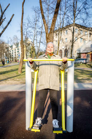 MINSK, BELARUS - 1 MAY, 2019: children, adults and old people exercise on outdoor exercise machinesのeditorial素材