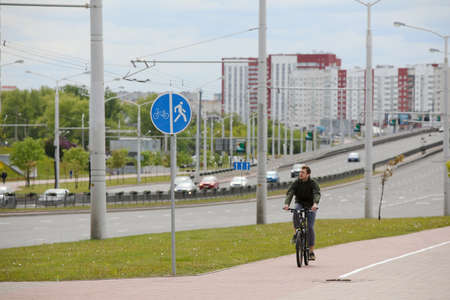MINSK, BELARUS - 1 OCTOBER, 2020: a man rides a bicycle on a bicycle lane in the city centerのeditorial素材