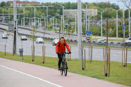 MINSK, BELARUS - 1 OCTOBER, 2020: a man rides a bicycle on a bicycle lane in the city centerのeditorial素材