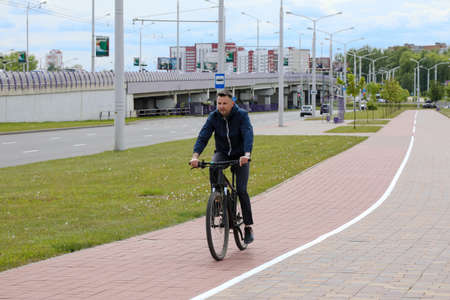 MINSK, BELARUS - 1 OCTOBER, 2020: a man rides a bicycle on a bicycle lane in the city centerのeditorial素材