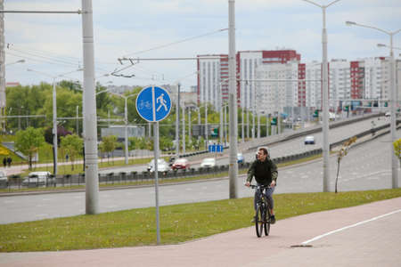 MINSK, BELARUS - 1 OCTOBER, 2020: a man rides a bicycle on a bicycle lane in the city centerのeditorial素材