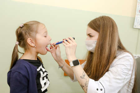 MINSK, BELARUS - 1 March, 2022: young doctor pediatrician examines a childのeditorial素材