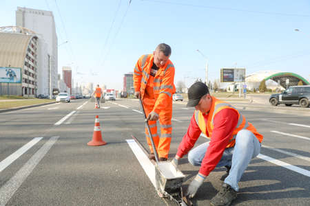 MINSK, BELARUS - 18 FEBRUARY, 2022: workers apply road markings on the roadの写真素材