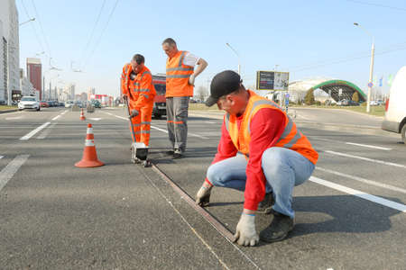MINSK, BELARUS - 18 FEBRUARY, 2022: workers apply road markings on the roadの写真素材