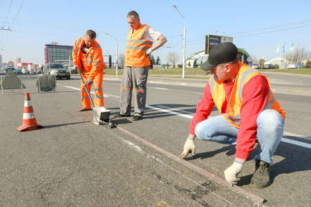 MINSK, BELARUS - 18 FEBRUARY, 2022: workers apply road markings on the roadの写真素材