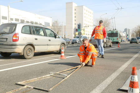 MINSK, BELARUS - 18 FEBRUARY, 2022: workers apply road markings on the roadのeditorial素材