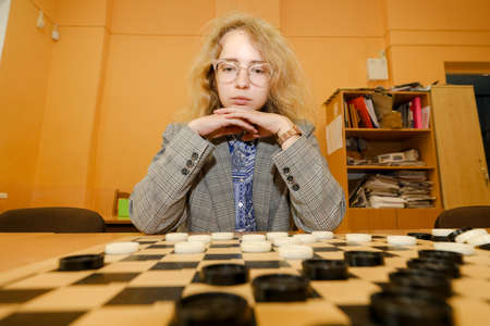 MINSK, BELARUS - 18 FEBRUARY, 2022: young girl playing checkersのeditorial素材