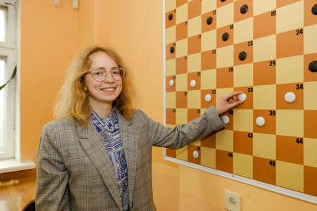 MINSK, BELARUS - 18 FEBRUARY, 2022: young girl playing checkersのeditorial素材