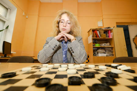 MINSK, BELARUS - 18 FEBRUARY, 2022: young girl playing checkersのeditorial素材