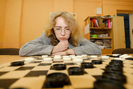 MINSK, BELARUS - 18 FEBRUARY, 2022: young girl playing checkersのeditorial素材