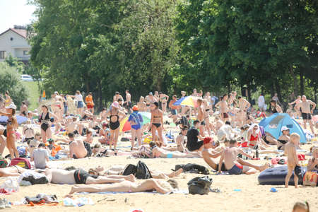 MINSK, BELARUS - 22 July, 2022: people sunbathing on the beach by the lake in the cityの写真素材