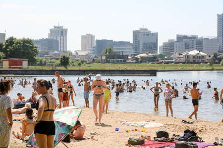 MINSK, BELARUS - 22 July, 2022: people sunbathing on the beach by the lake in the cityの写真素材
