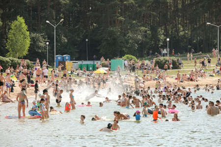 MINSK, BELARUS - 22 July, 2022: people sunbathing on the beach by the lake in the cityの写真素材