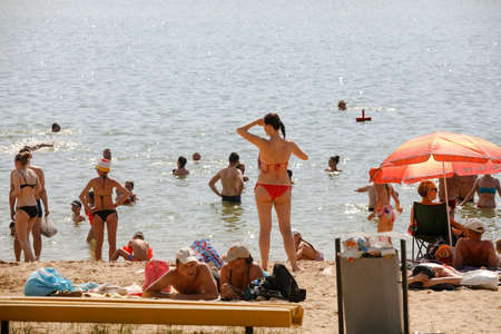 MINSK, BELARUS - 22 July, 2022: people sunbathing on the beach by the lake in the cityの写真素材